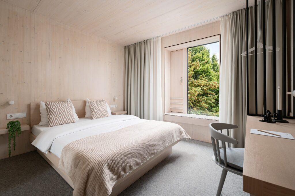 ein gemütliches modernes Zimmer mit einem großen Fenster und vielen Holzelementen